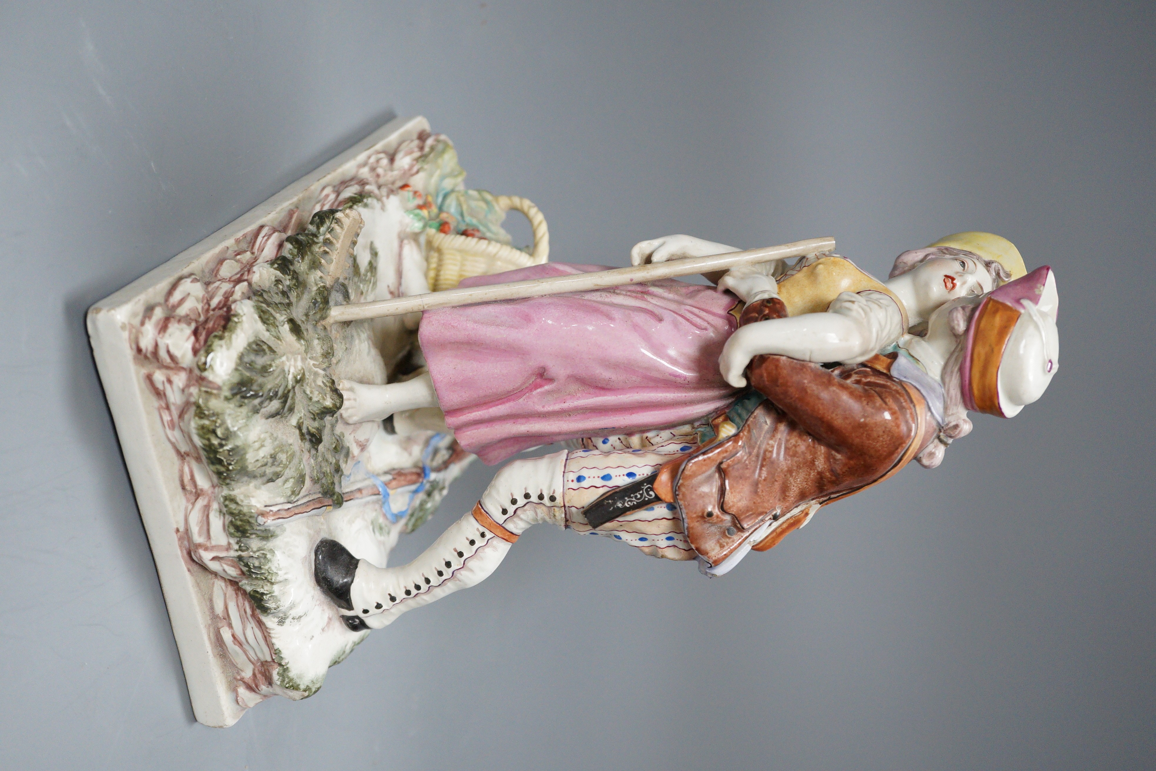 A 19th century Continental figure group of a huntsman embracing a female peasant, 23cm